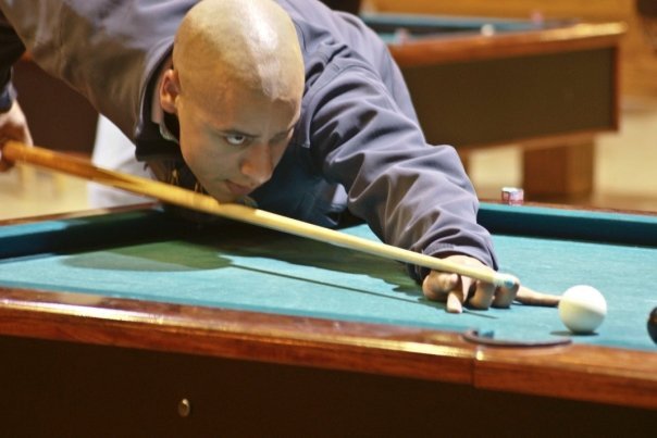 Justin Boyd leans across a pool table as he lines up his shot