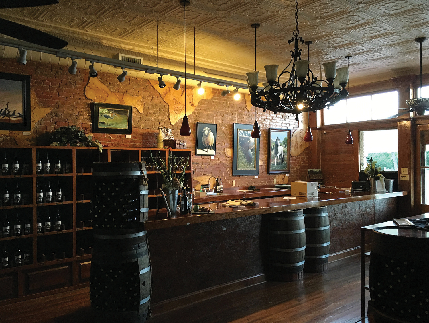 The tasting room of Kissing Tree has a bar and several barrels of wine