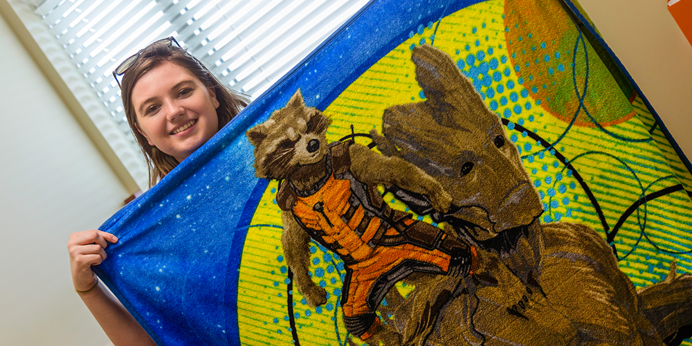Abby Hughes finds comfort in her “Guardians of the Galaxy” blanket — it’s her favorite movie and Rocket the raccoon reminds her of her high school mascot.
