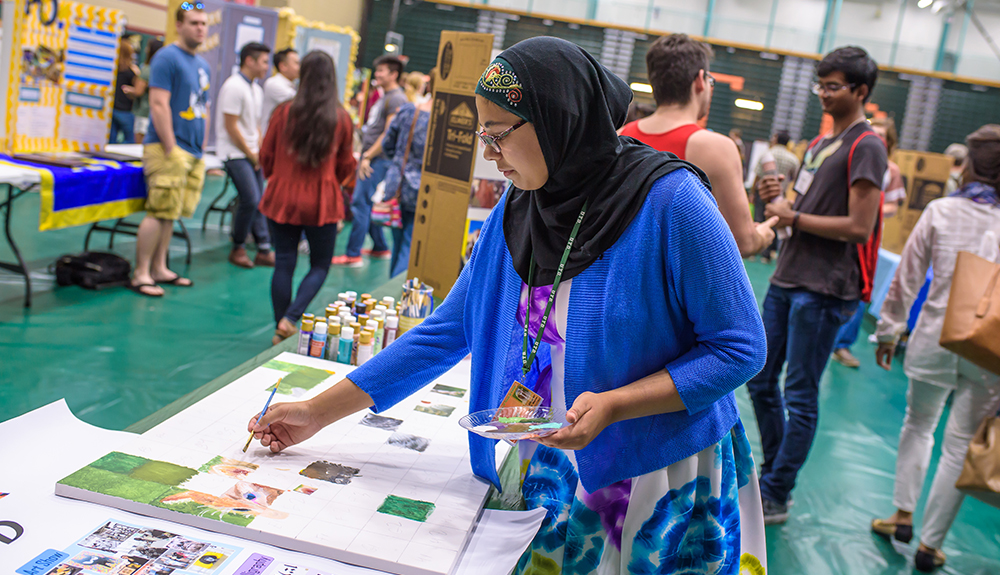 Khadijah Mazhar of Art UTD invited attendees to paint individual squares for a collaborative art piece.