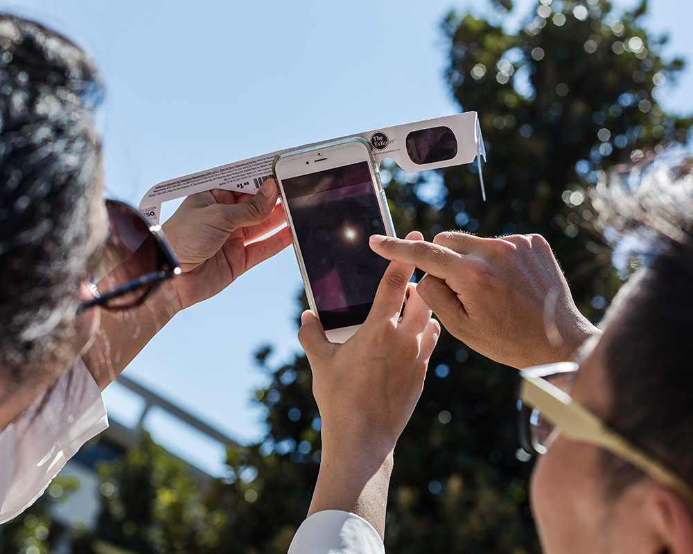 Maryam Ahmadi and Taeho Yoon photographed the eclipse on their phone with special glasses as a filter.