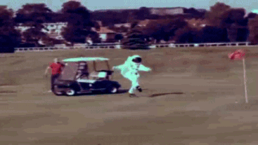 A person in an astronaut suit bouncing around a golf course