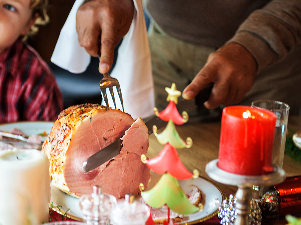 Photo of someone carving a holiday ham