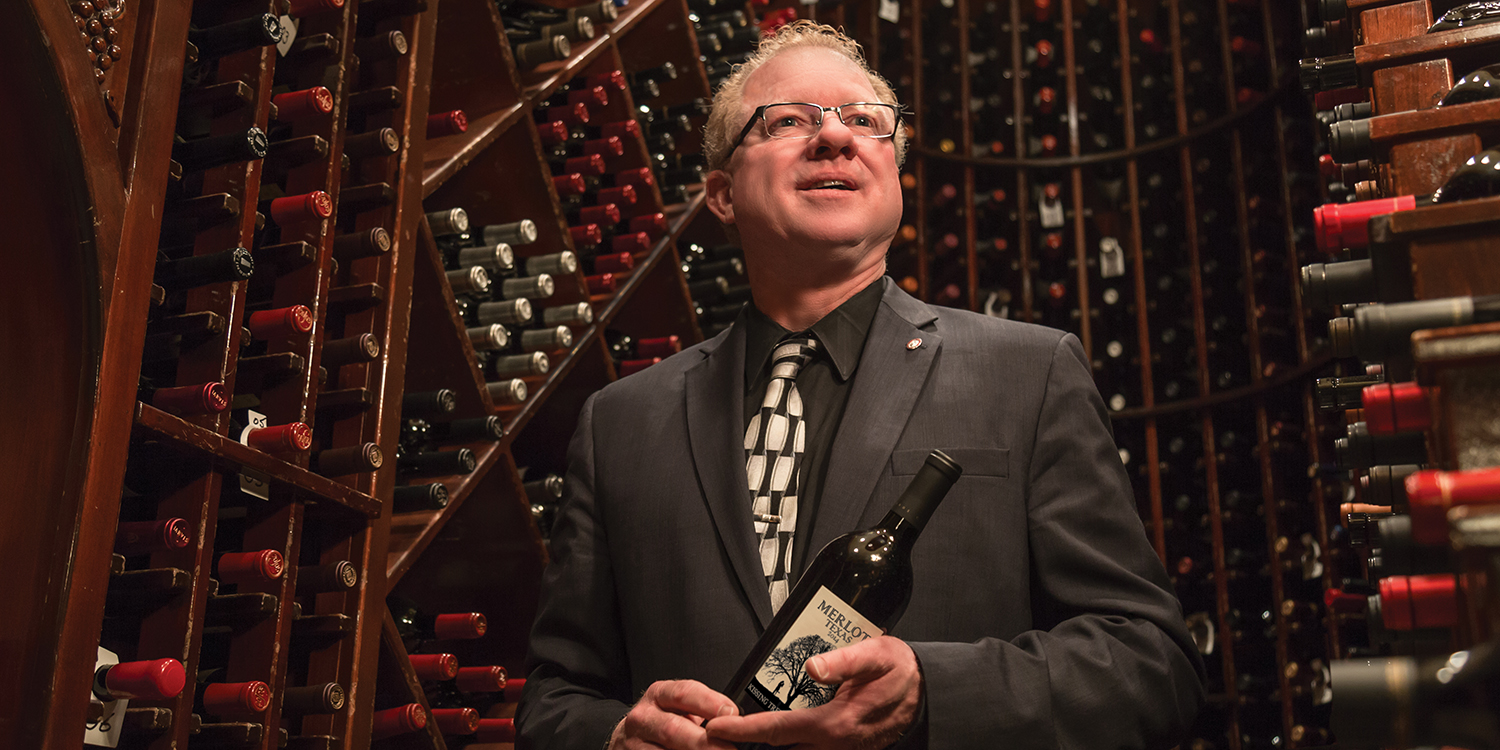 Photo of Dennis Haley holding a bottle of wine