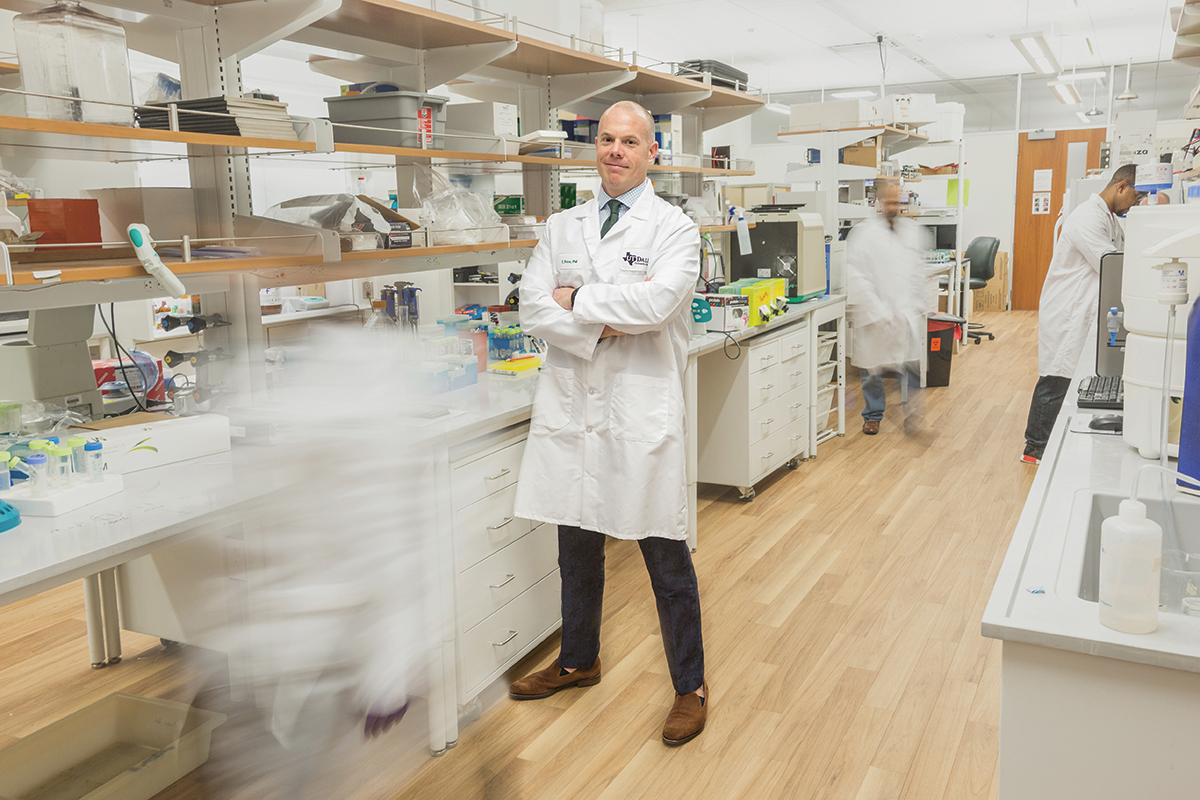 Dr. Ted Price stands with his arms crossed in a lab