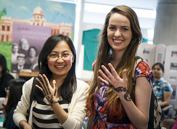 Yi Li (left) and Rachel Crews show off their henna designs at a Galerstein Womens Center event during International Week in 2015