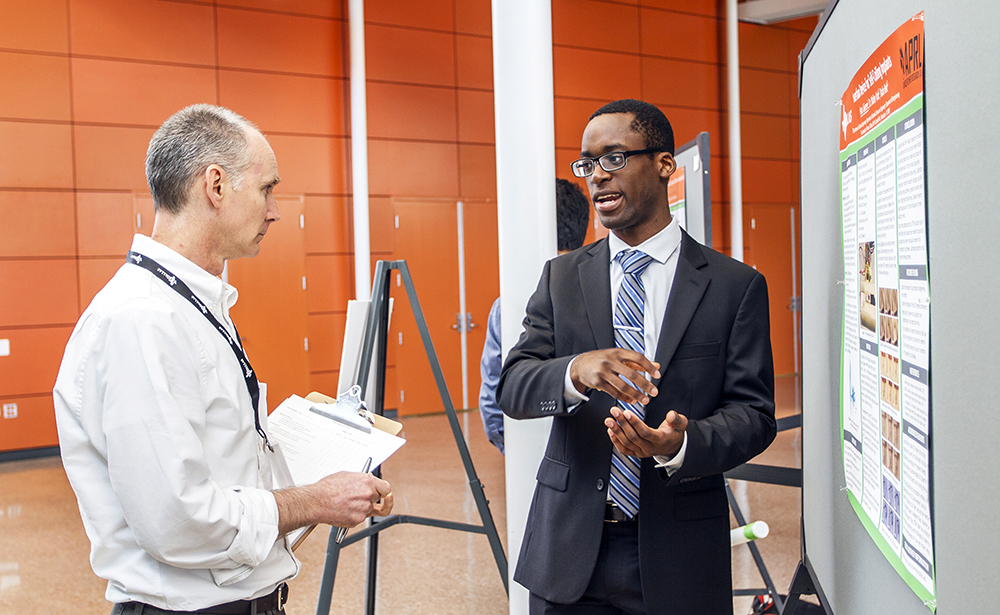 Hans Ajieren, a Eugene McDermott Scholar and in electrical engineering sophomore, explains his work on cochlear implants to contest judge Todd Edwards, an engineer at Raytheon. Ajieren earned third place