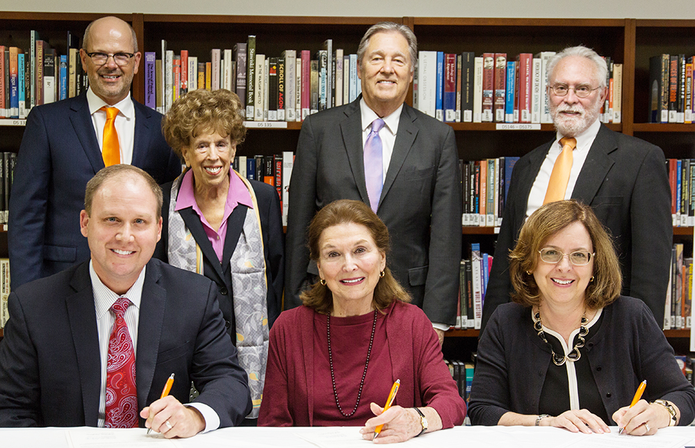 UT Dallas officials and Dr. Marcia Sachs Littell (front row, center), immediate past president of the Annual Scholars Conference on the Holocaust and the Churches, sign an agreement to make the University the new home of the conference. The conference will be on March 3-5 at the Davidson-Gundy Alumni Center. 