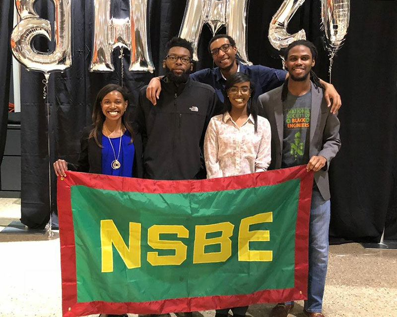 National Society of Black Engineers pose with their group flag