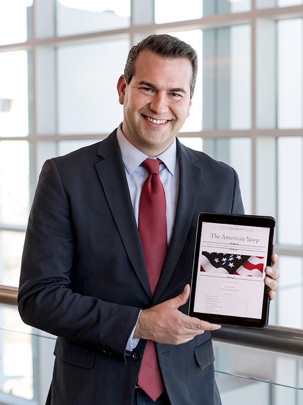 Dr. Ben Wright holding a tablet that is displaying The American Yawp