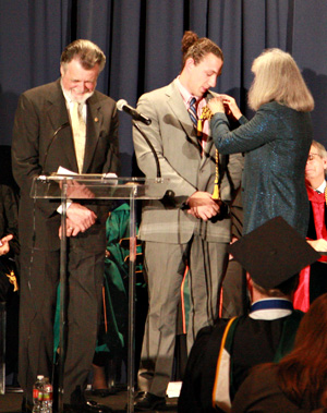 Evan Baldwin Carr being pinned by mother during Phi Kappa Phi ceremony