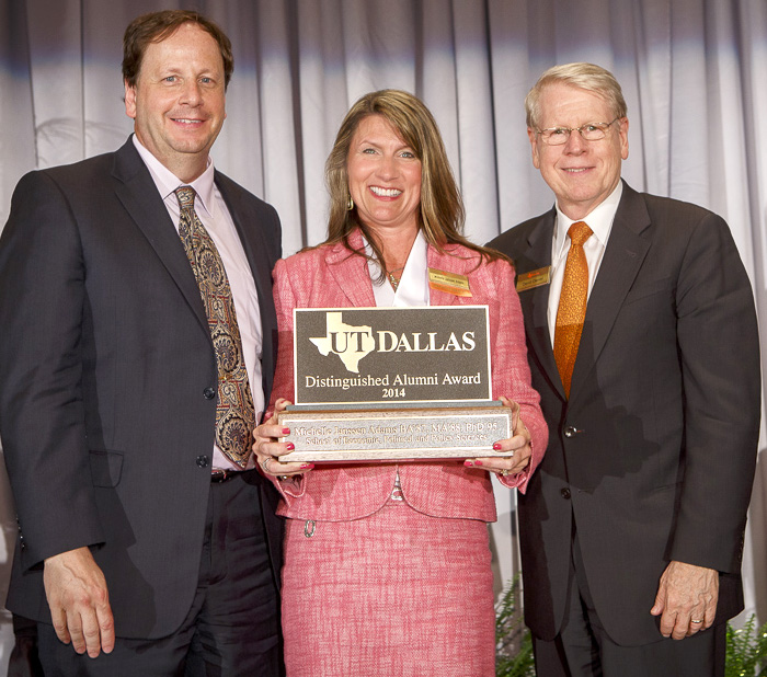 Michelle Adams BA87, MA88, PhD95 accepts the Distinguished Alumni Award from Dr. Denis Dean, dean of the School of Economic, Political and Policy Sciences (left), and President David E. Daniel.