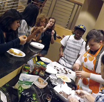 Students tasting food served as a residence hall cooking demonstration