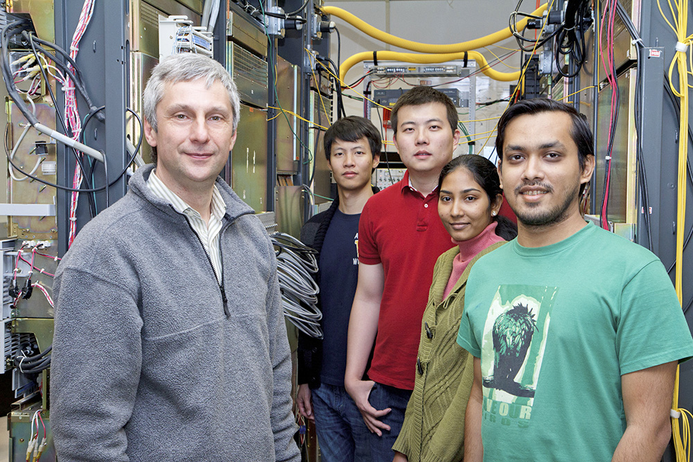 Dr. Andrea Fumagalli (left) and students inside his SONET (Synchronous Optical Network) optical communication system.