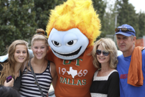 A family takes a photo with UTD mascot Temoc