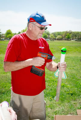 Dr. Phil Anderson uses a drill to attach sections of a contestant’s rocket.
